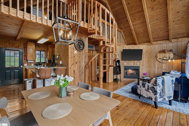 dining area with hardwood / wood-style flooring, beamed ceiling, and wooden ceiling