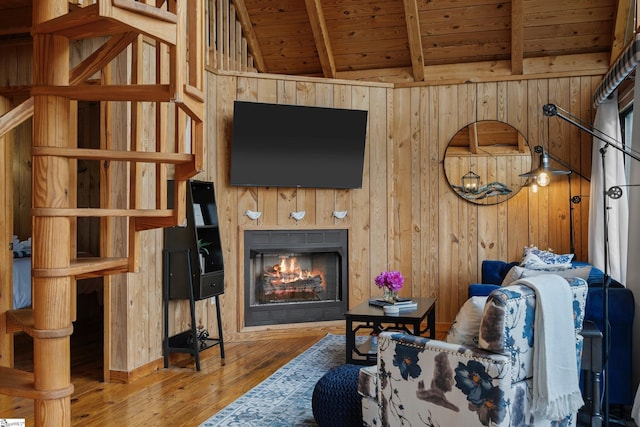 living room featuring wood ceiling, hardwood / wood-style flooring, wooden walls, and vaulted ceiling with beams