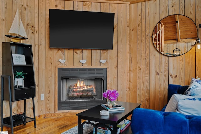 living room with wood-type flooring and wooden walls