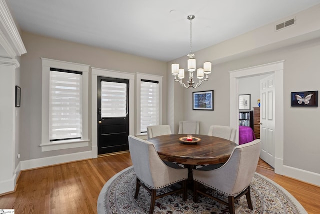 dining space with a chandelier and light hardwood / wood-style flooring