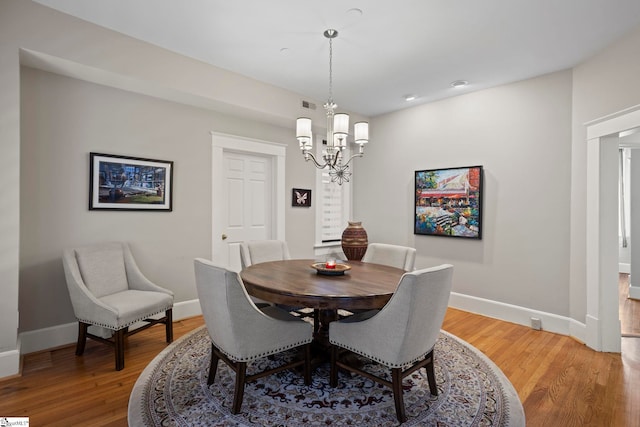 dining space featuring an inviting chandelier and hardwood / wood-style floors