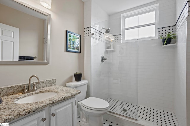 bathroom featuring vanity, toilet, and tiled shower