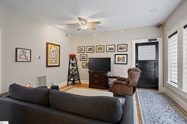 living room with ceiling fan and light hardwood / wood-style flooring