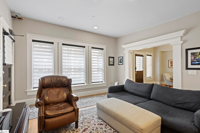 living room with wood-type flooring and decorative columns