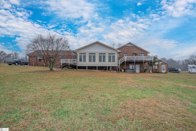 view of front of house featuring a front yard, a sunroom, and a deck