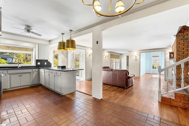 kitchen featuring sink, white cabinetry, crown molding, white dishwasher, and kitchen peninsula