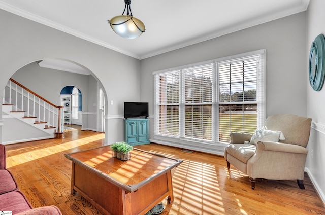 living room with ornamental molding and light hardwood / wood-style floors