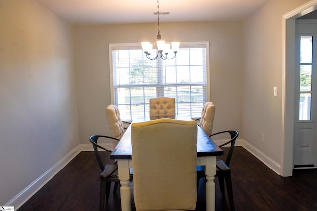 dining room with dark wood-type flooring and an inviting chandelier