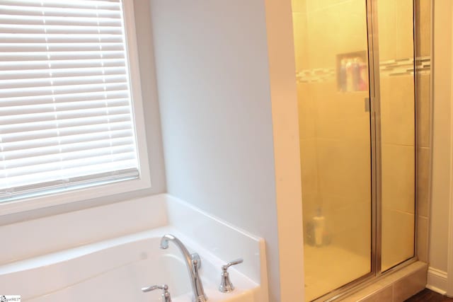 bathroom featuring separate shower and tub