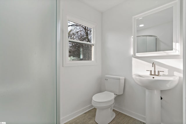 bathroom featuring wood-type flooring and toilet