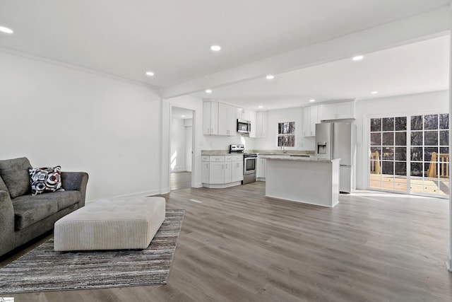 living room featuring beamed ceiling and light wood-type flooring