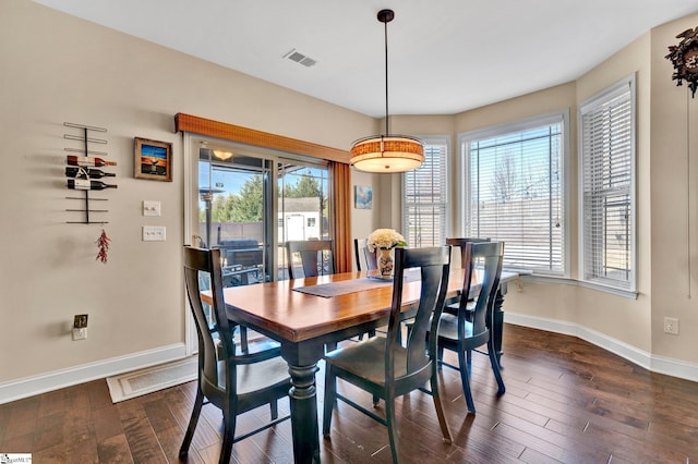 dining room with dark hardwood / wood-style floors and a wealth of natural light