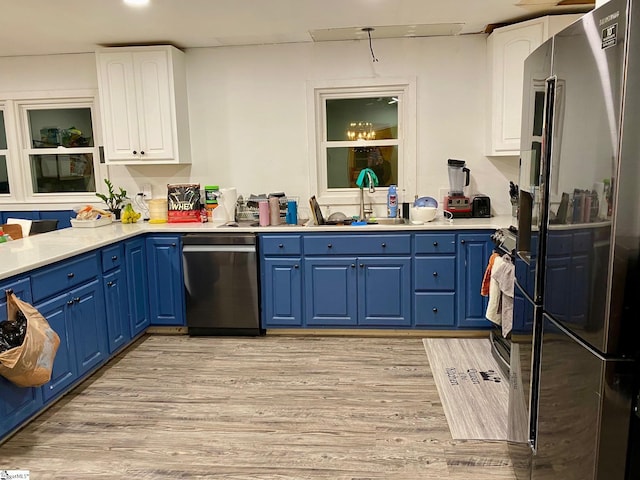 kitchen featuring blue cabinets, sink, white cabinetry, fridge, and stainless steel dishwasher