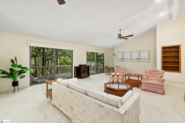 carpeted living room with ceiling fan and vaulted ceiling