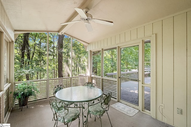 sunroom / solarium featuring ceiling fan and vaulted ceiling with beams