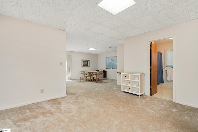 carpeted empty room with a drop ceiling