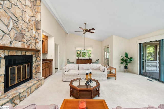 living room with a fireplace, ceiling fan, vaulted ceiling, and light colored carpet