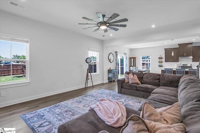 living room featuring ceiling fan and dark hardwood / wood-style floors