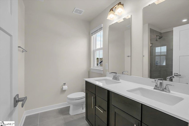 bathroom with tile patterned floors, toilet, vanity, and tiled shower