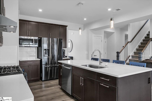 kitchen with decorative light fixtures, an island with sink, stainless steel appliances, and sink