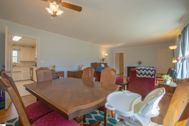 dining space with light hardwood / wood-style flooring, sink, and ornamental molding