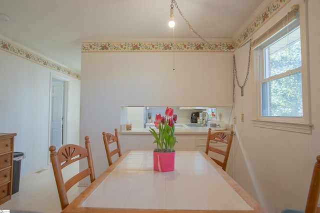 dining area featuring sink and ornamental molding