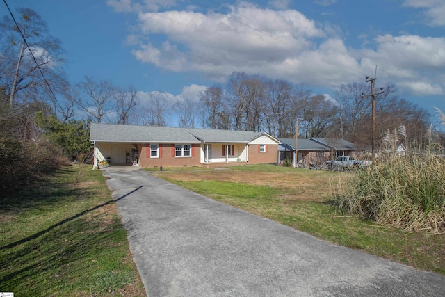 single story home with a porch, a front lawn, and a carport