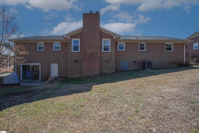 rear view of property featuring central AC and a lawn