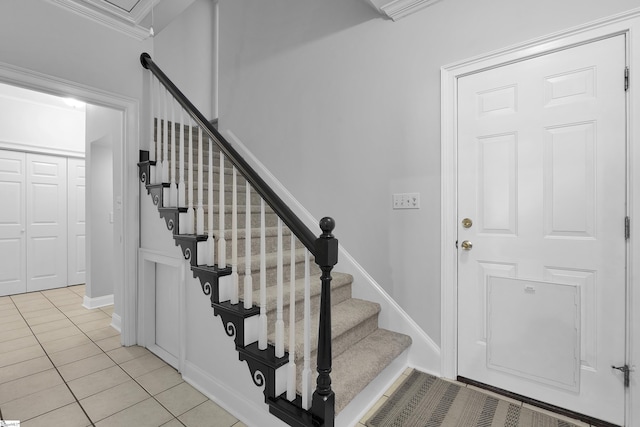 stairway featuring crown molding and tile patterned floors