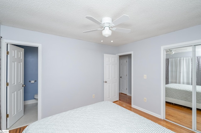 bedroom with light wood-type flooring, a closet, ceiling fan, and a textured ceiling