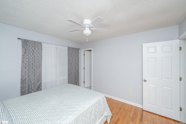 bedroom featuring a textured ceiling, hardwood / wood-style floors, and ceiling fan