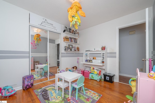 playroom with a textured ceiling and hardwood / wood-style floors