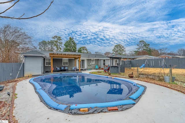 view of swimming pool featuring a playground, a patio, and a pergola