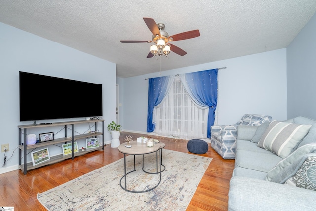 living room featuring a textured ceiling, ceiling fan, and wood-type flooring