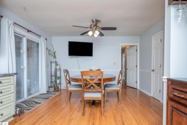 dining space featuring light hardwood / wood-style flooring, ceiling fan, and a textured ceiling