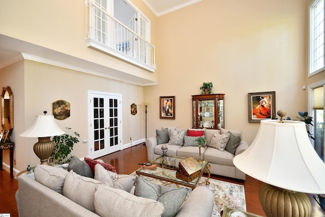 living room with dark wood-type flooring, a high ceiling, crown molding, and french doors