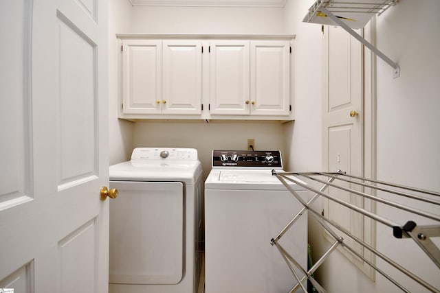 laundry room featuring cabinets and washer and clothes dryer