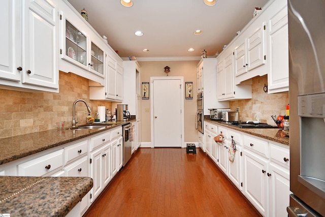 kitchen featuring dark stone countertops, white cabinetry, sink, and appliances with stainless steel finishes