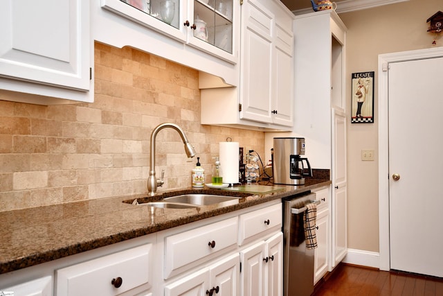 kitchen with dark stone countertops, sink, white cabinetry, stainless steel dishwasher, and decorative backsplash