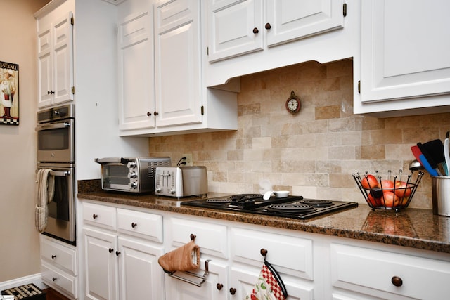 kitchen featuring black stovetop, white cabinetry, stainless steel double oven, and decorative backsplash