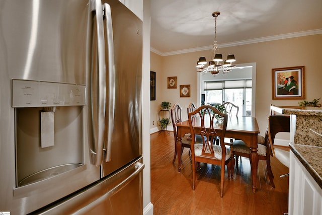 dining room with light hardwood / wood-style flooring, crown molding, and an inviting chandelier