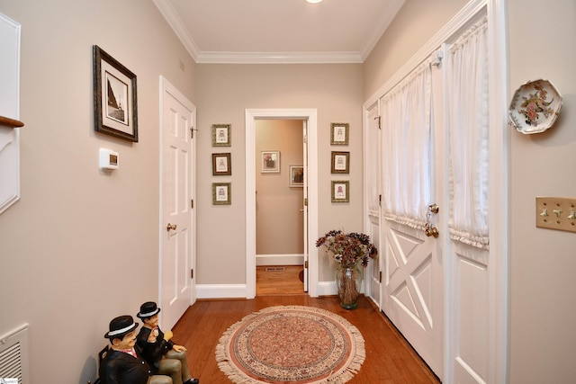 foyer featuring hardwood / wood-style floors and crown molding