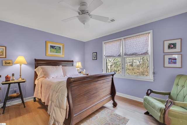 bedroom featuring ceiling fan, ornamental molding, and light hardwood / wood-style floors