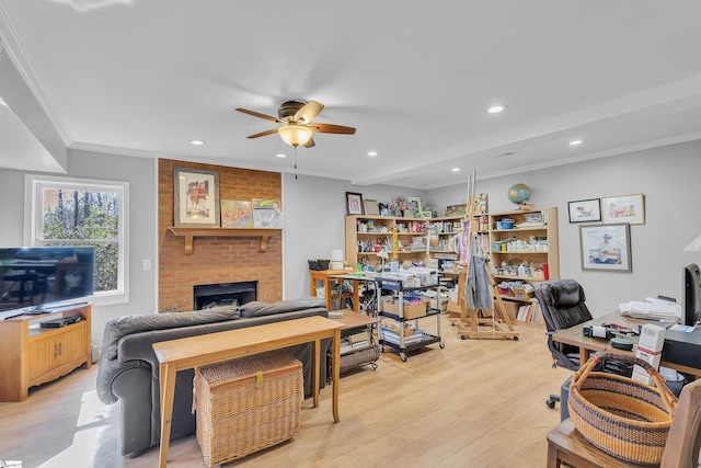 home office featuring a brick fireplace, light hardwood / wood-style floors, ceiling fan, and ornamental molding