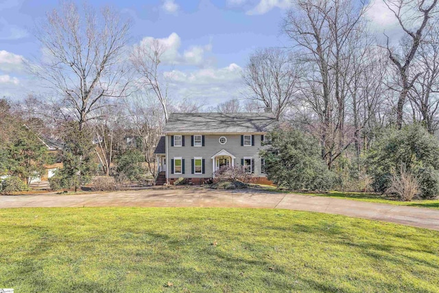 colonial inspired home with a front lawn