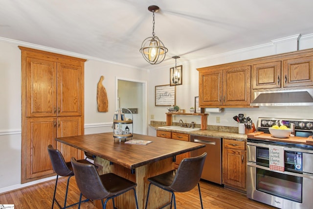 kitchen featuring hardwood / wood-style flooring, hanging light fixtures, stainless steel appliances, a center island, and sink