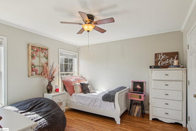 bedroom with ceiling fan, light wood-type flooring, and crown molding