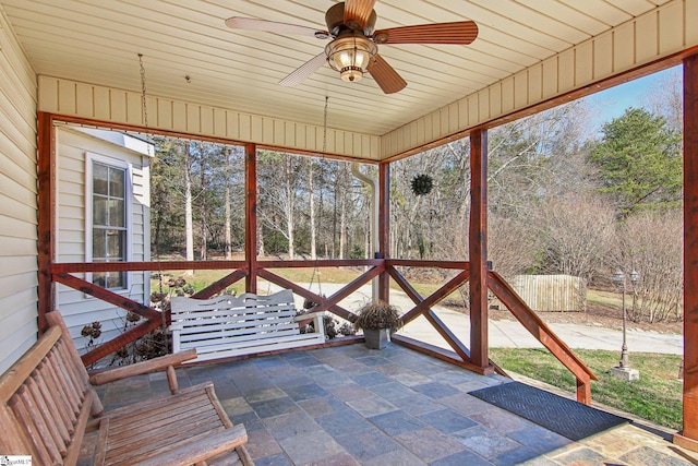 unfurnished sunroom with ceiling fan