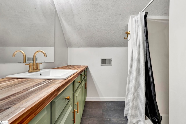 bathroom with vanity, a textured ceiling, and lofted ceiling