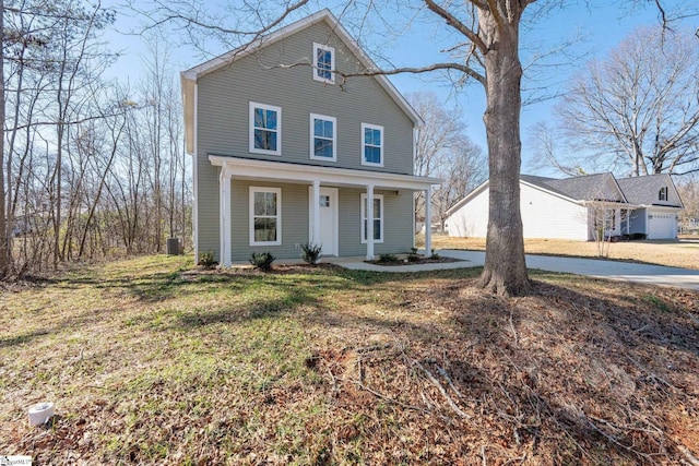 front facade with covered porch, a front yard, and cooling unit